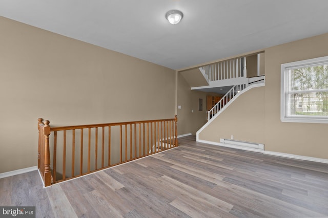 empty room featuring light hardwood / wood-style floors and a baseboard heating unit