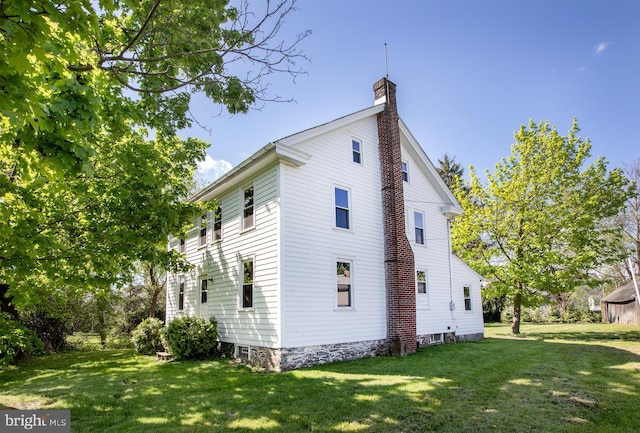 back of house featuring a lawn