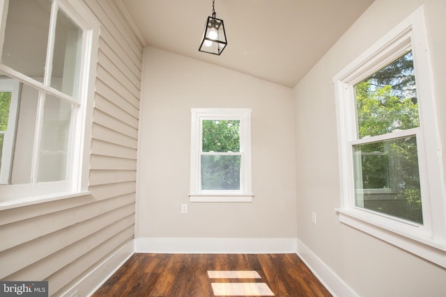 spare room featuring vaulted ceiling and hardwood / wood-style flooring