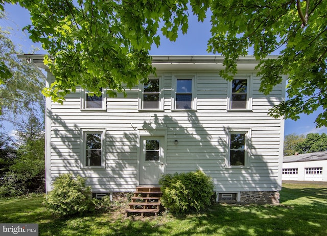 rear view of property featuring a lawn