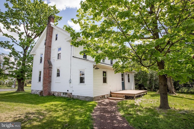 rear view of property featuring a deck and a yard