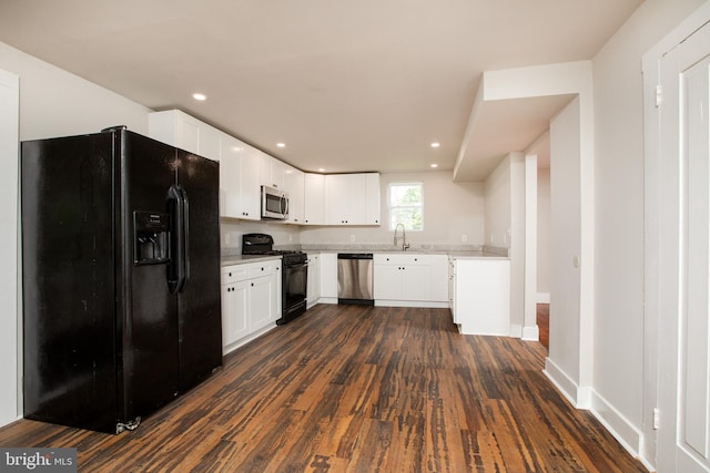 kitchen featuring light stone counters, sink, white cabinetry, dark wood-type flooring, and black appliances