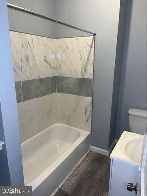 full bathroom featuring vanity, hardwood / wood-style flooring, toilet, and tub / shower combination