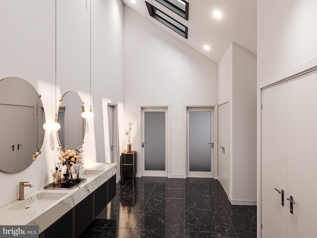 bathroom with high vaulted ceiling and vanity