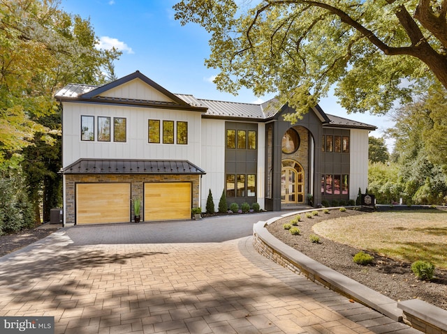 modern farmhouse style home featuring cooling unit and a garage