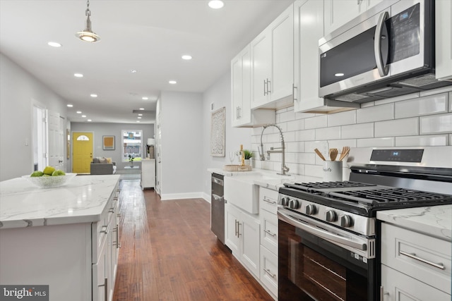 kitchen featuring white cabinets, dark hardwood / wood-style floors, pendant lighting, and stainless steel appliances