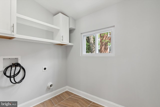 clothes washing area with washer hookup, electric dryer hookup, cabinets, and hardwood / wood-style floors