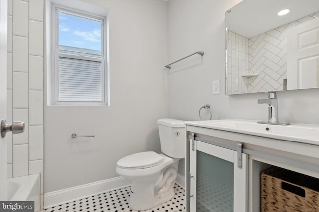 bathroom featuring tile flooring, vanity, and toilet