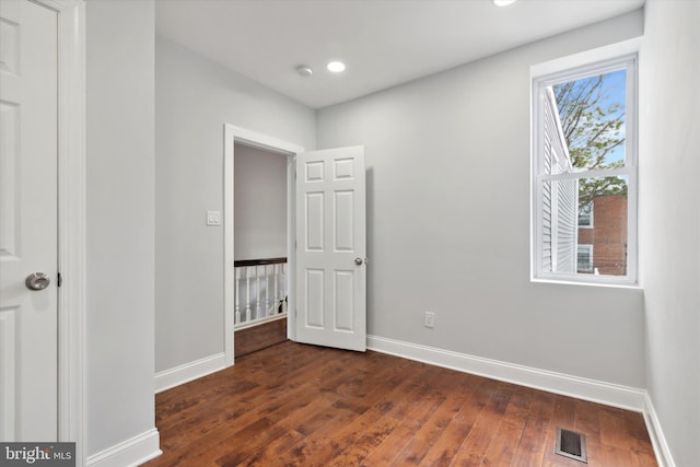 spare room featuring dark wood-type flooring