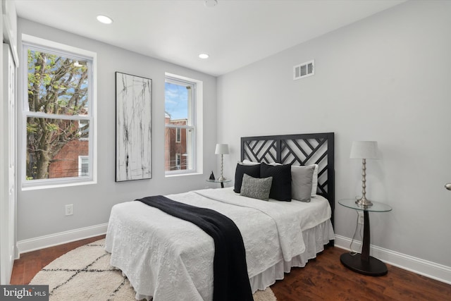 bedroom with dark hardwood / wood-style flooring and multiple windows