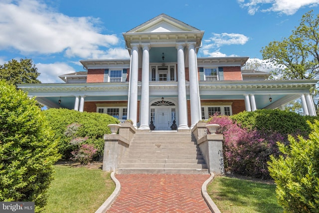 greek revival house with a front yard and french doors