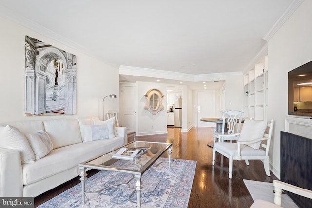 living room featuring crown molding, built in features, wood finished floors, and baseboards