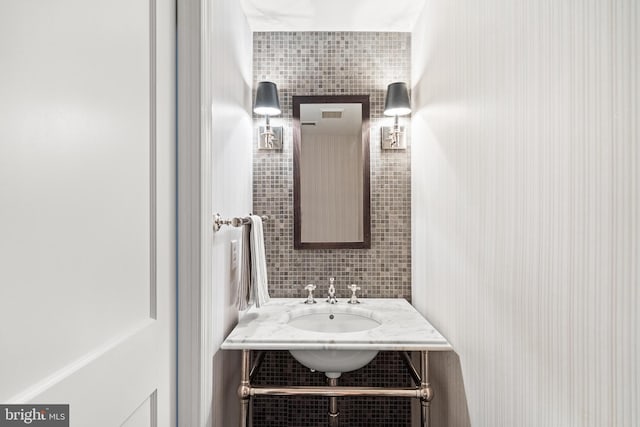 bathroom with tile walls, tasteful backsplash, and a sink