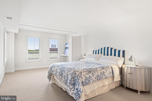 bedroom with visible vents, light colored carpet, and baseboards