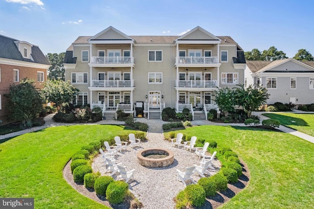 exterior space featuring a lawn, a patio area, and an outdoor fire pit