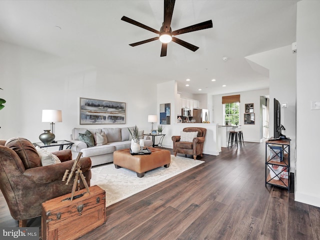 living room with dark hardwood / wood-style flooring and ceiling fan