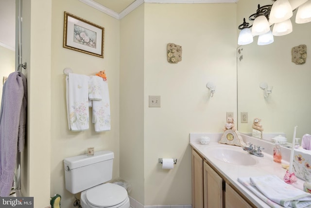 bathroom with vanity, toilet, and ornamental molding