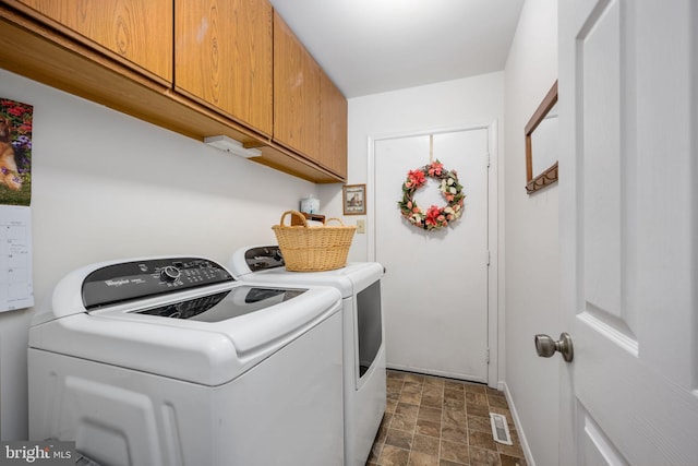 washroom with cabinets and washer and dryer