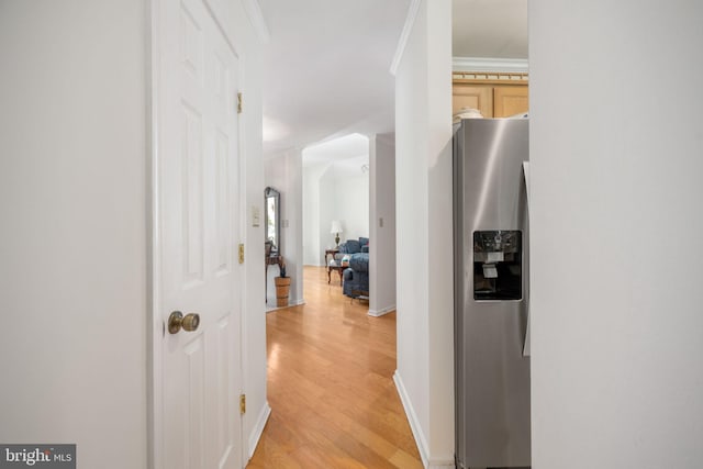 hall featuring light wood-type flooring and crown molding