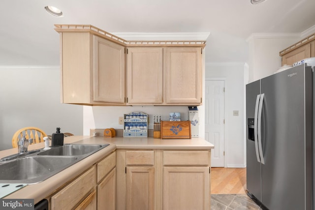 kitchen featuring sink, stainless steel refrigerator with ice dispenser, kitchen peninsula, crown molding, and light brown cabinetry