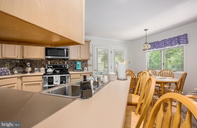 kitchen with appliances with stainless steel finishes, light hardwood / wood-style flooring, crown molding, and light brown cabinetry