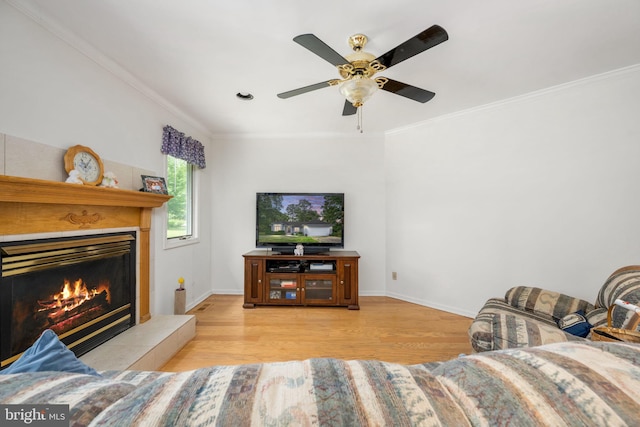 living room featuring crown molding, light hardwood / wood-style flooring, and ceiling fan