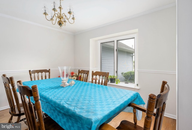 dining area featuring crown molding, a chandelier, and hardwood / wood-style flooring