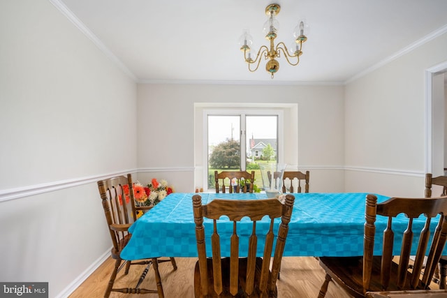 dining space featuring a chandelier, wood-type flooring, and crown molding