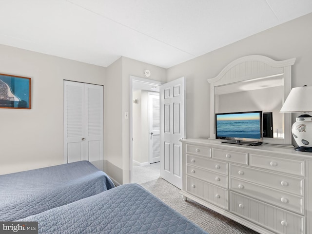 bedroom featuring light colored carpet and a closet