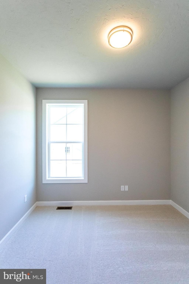 carpeted spare room featuring a textured ceiling