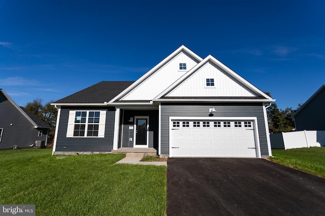 craftsman-style home with cooling unit, a garage, and a front lawn