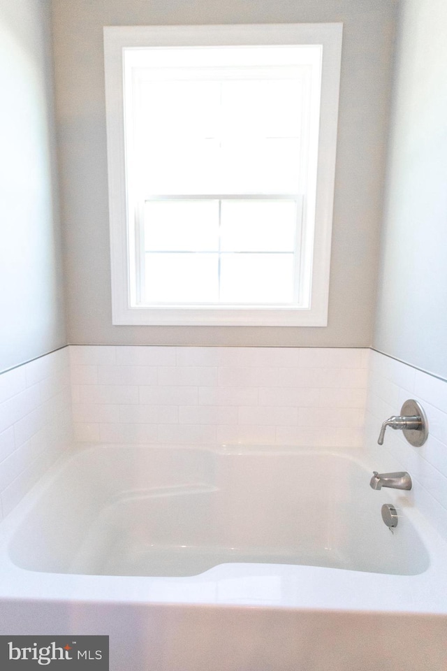 bathroom featuring a bathing tub and a wealth of natural light