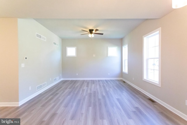 empty room with ceiling fan and light hardwood / wood-style flooring