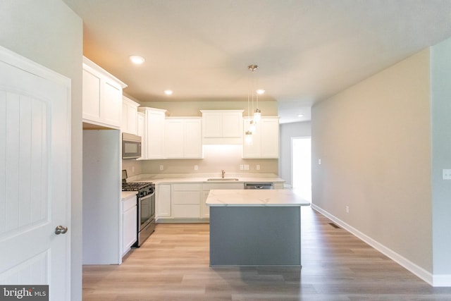 kitchen with white cabinetry, a center island, and appliances with stainless steel finishes