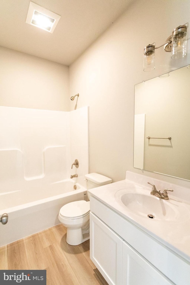 full bathroom featuring shower / washtub combination, vanity, wood-type flooring, and toilet