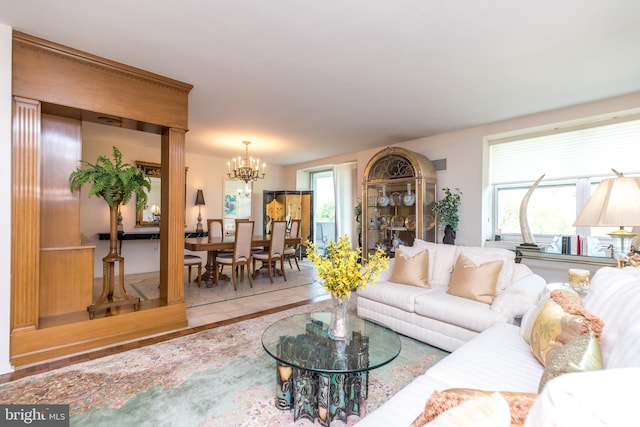 living room with wood-type flooring, a chandelier, and a wealth of natural light