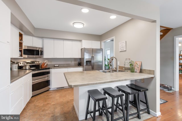 409 Hilltop Rd, Strasburg, PA 17579 - kitchen with appliances with stainless steel finishes, white cabinets, sink, and a breakfast bar area