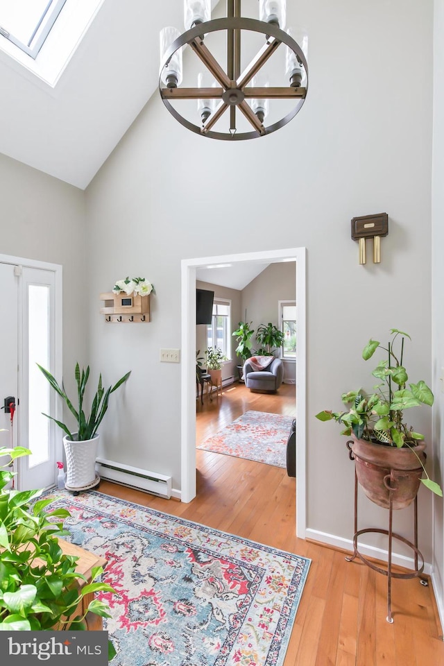 409 Hilltop Rd, Strasburg, PA 17579 - entrance foyer with high vaulted ceiling, hardwood / wood-style flooring, a skylight, a baseboard radiator, and an inviting chandelier