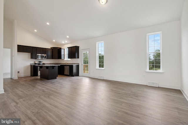 kitchen with a breakfast bar, a wealth of natural light, stainless steel appliances, and a kitchen island