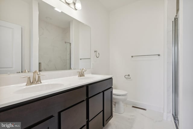 bathroom featuring a shower with door, vanity, and toilet