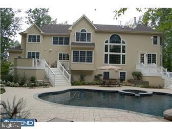 view of swimming pool featuring a patio area and an in ground hot tub