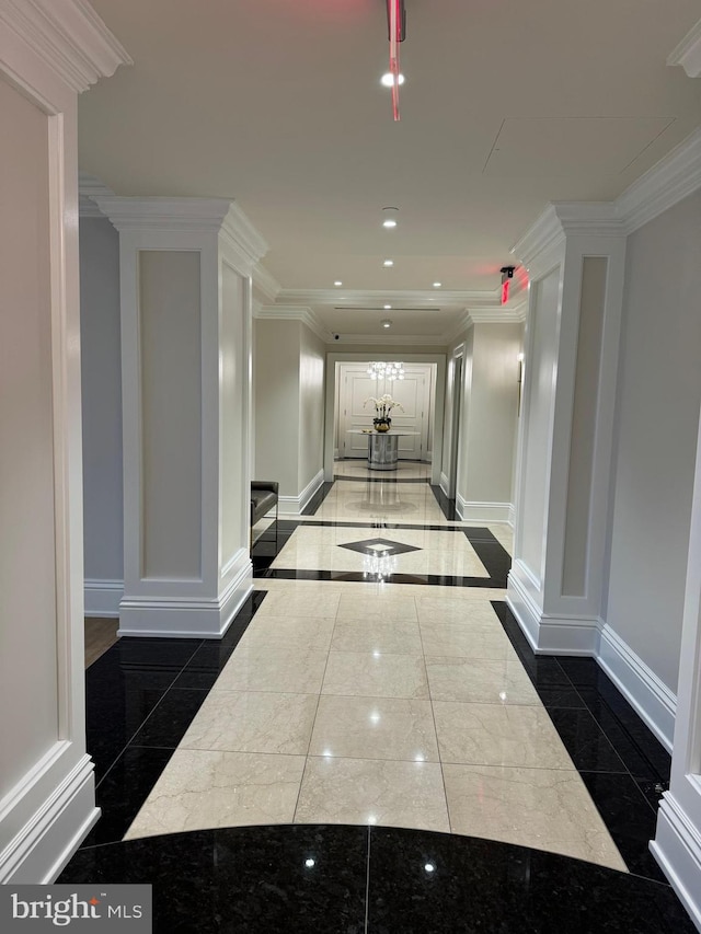 hall with dark tile flooring and crown molding