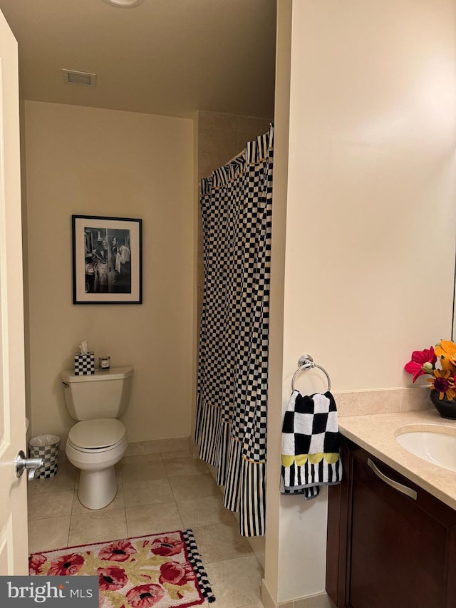 bathroom with vanity, tile floors, and toilet