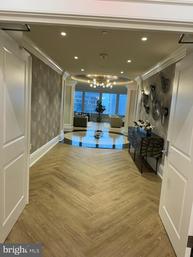 corridor featuring a notable chandelier, light parquet flooring, and crown molding