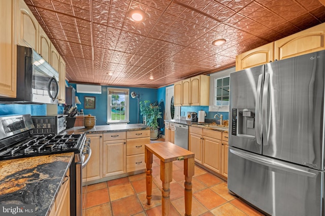 kitchen with light brown cabinets, crown molding, and stainless steel appliances