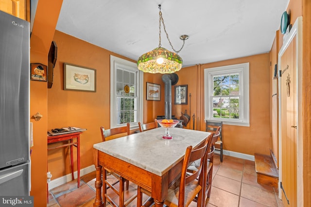 tiled dining room with a wood stove