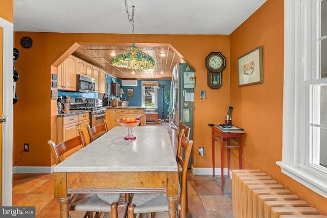 dining room featuring radiator, light tile patterned flooring, and a chandelier