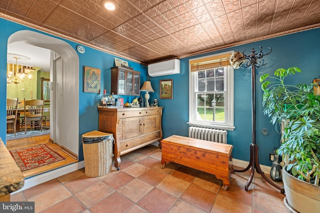 living area featuring an inviting chandelier, a wall unit AC, radiator, and crown molding