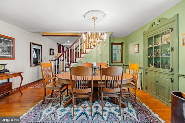 dining room featuring wood-type flooring and an inviting chandelier