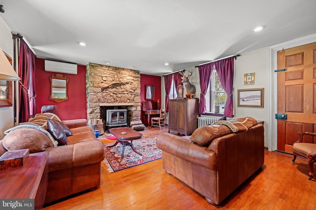 living room with light wood-type flooring and a wall unit AC